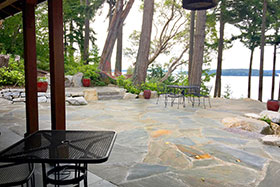 The flagstone patio flows from the kitchen without any grade change, taking advantage of the view of Puget Sound. Together with a small raised patio on the left, the client stated